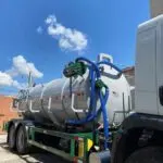 Caminhão tanque em operação com mangueira azul